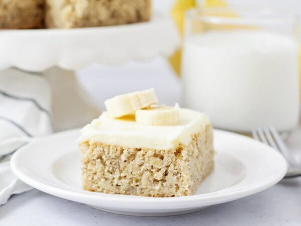 A slice of frosted banana bars on a white plate.
