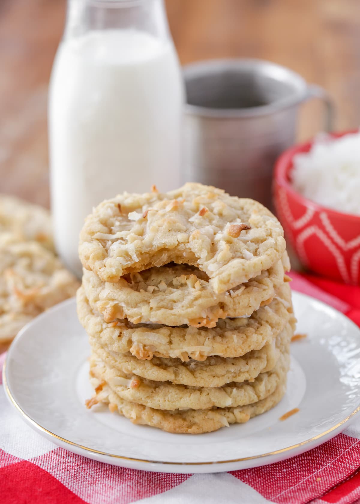 Coconut cookies stacked on a wooden table.