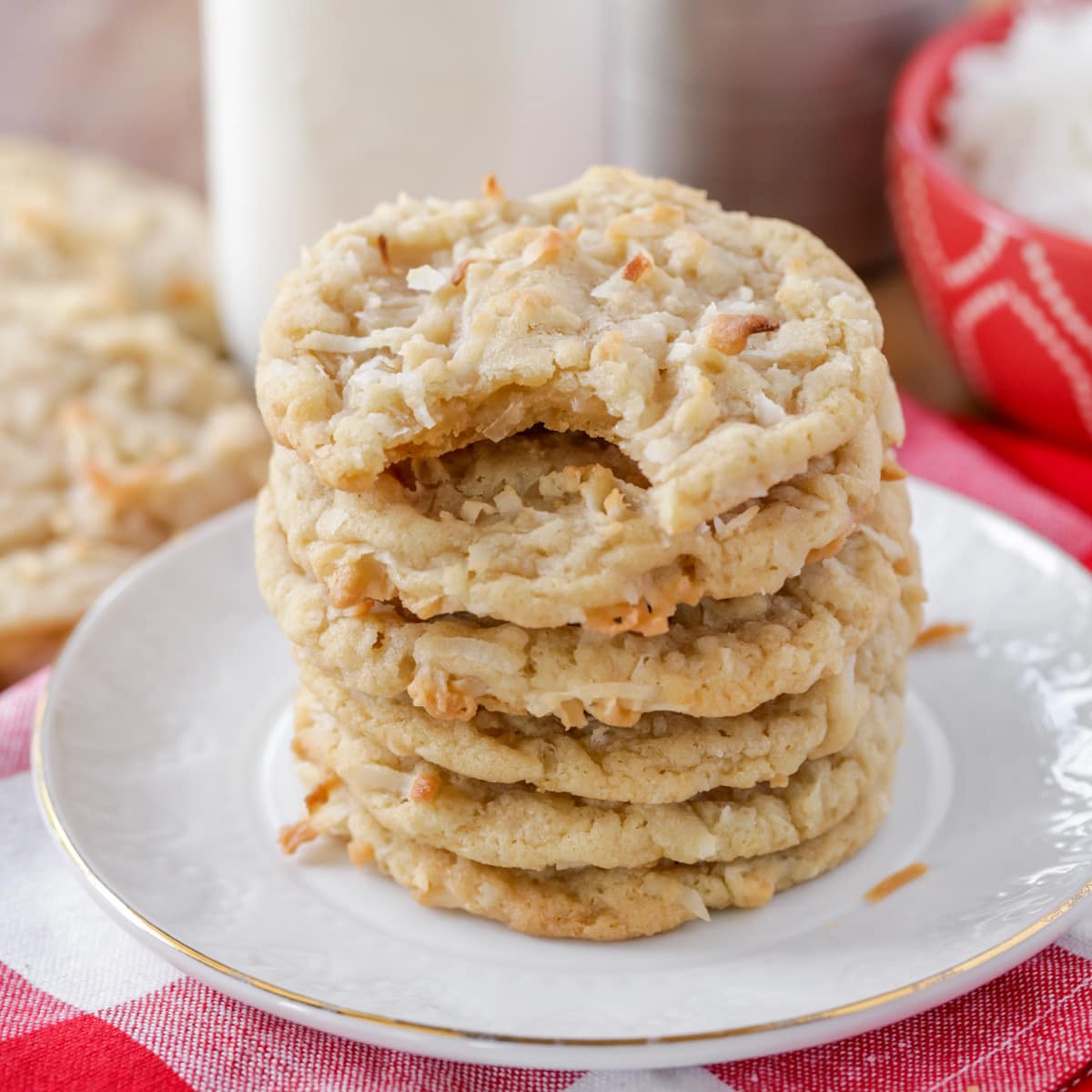 Chewy Coconut cookies stacked on wooden table.