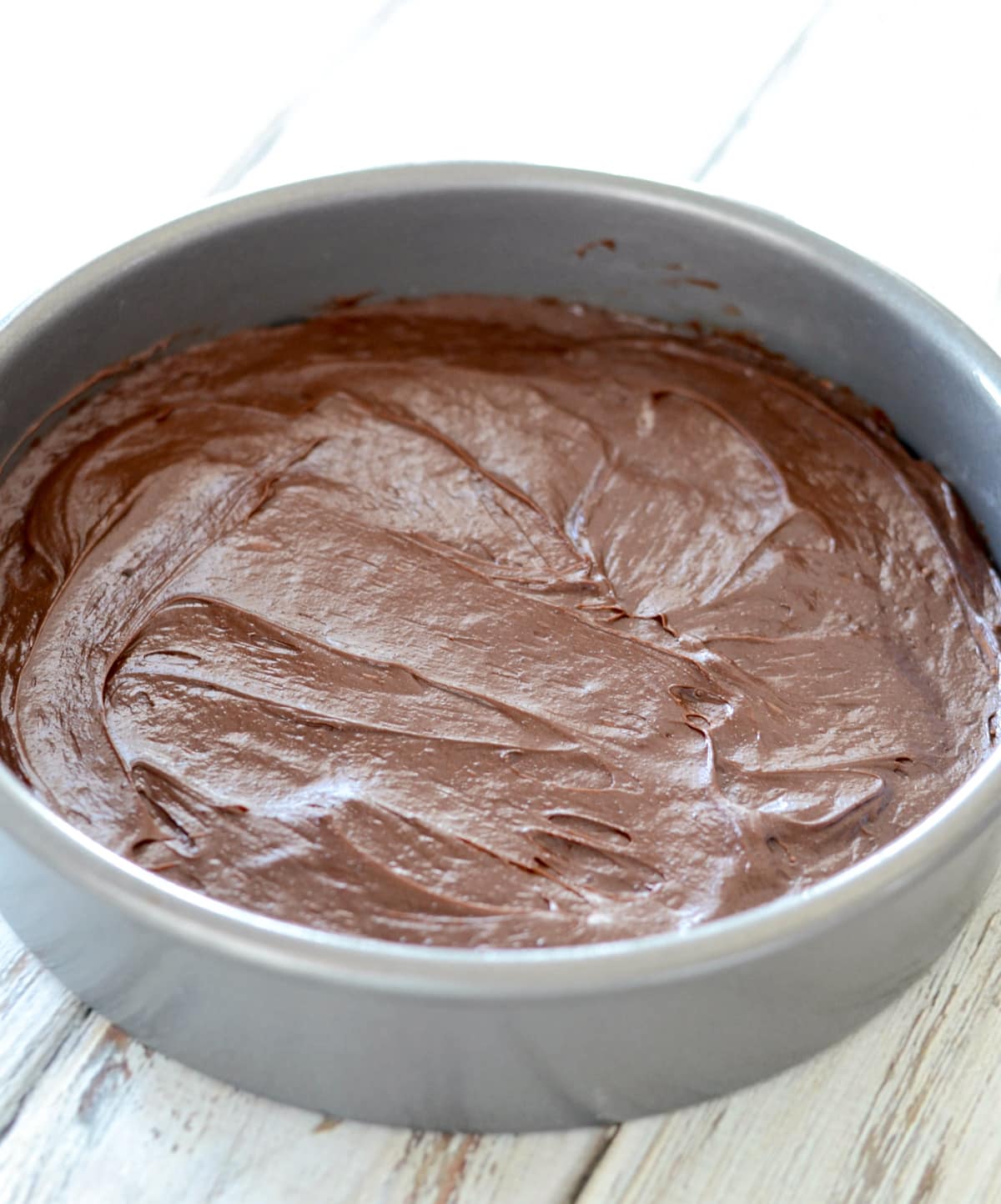 Chocolate cake batter in circle pan.