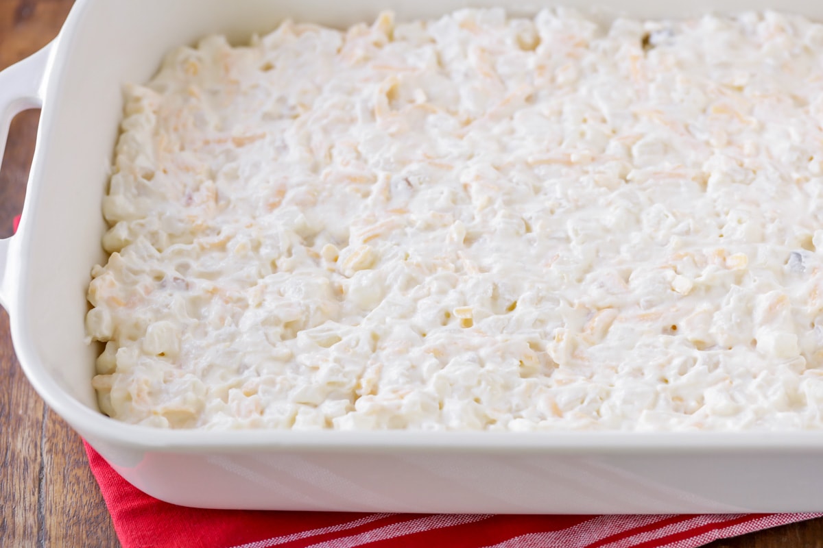 Funeral potatoes poured into baking dish.