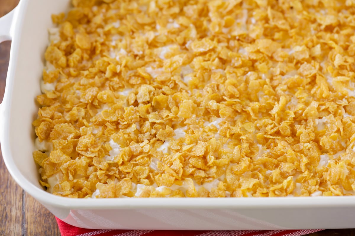 A white casserole dish with funeral potatoes in it.