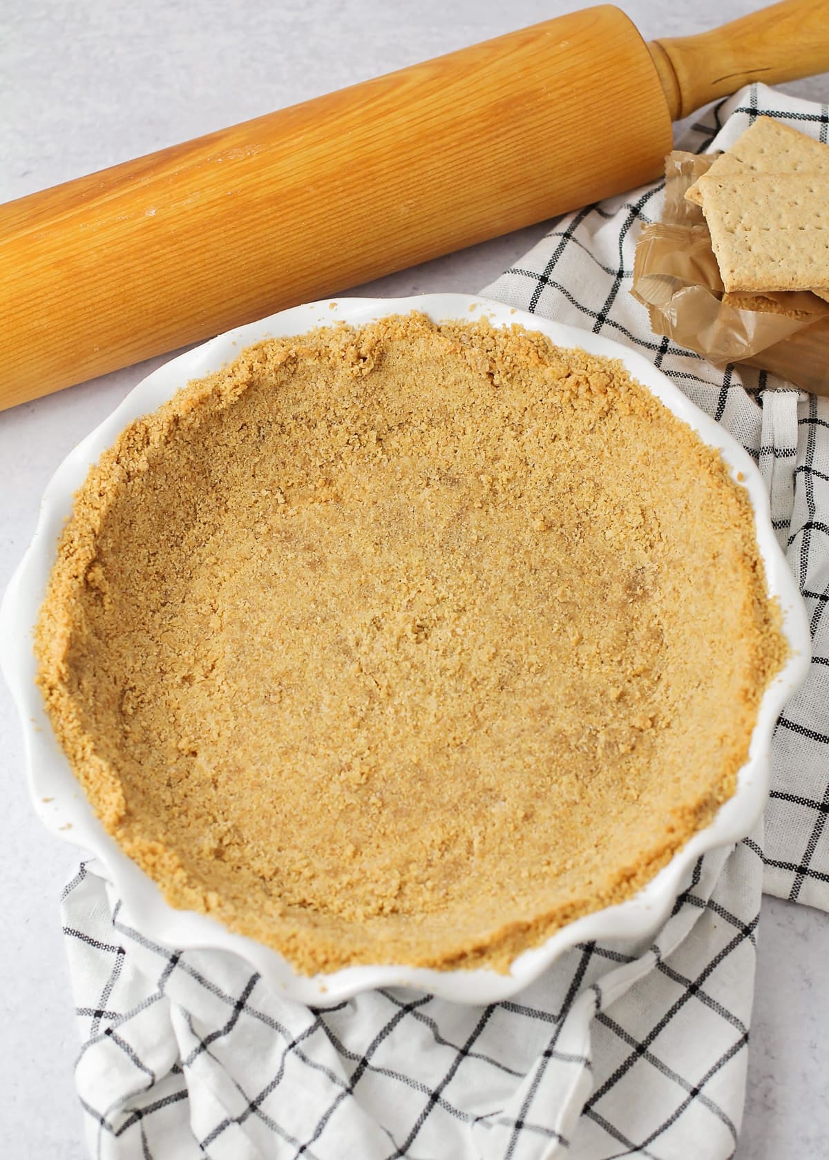 Top view of a pressed graham cracker crust in a pie dish.