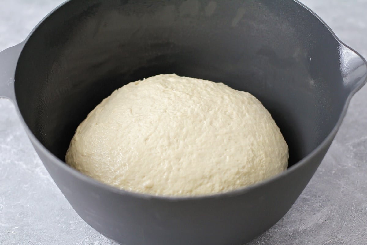 Homemade bread dough rising in bowl.