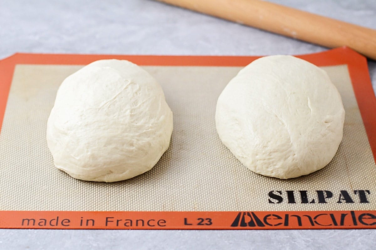 Dough cut in half and placed in two balls on a Silpat.