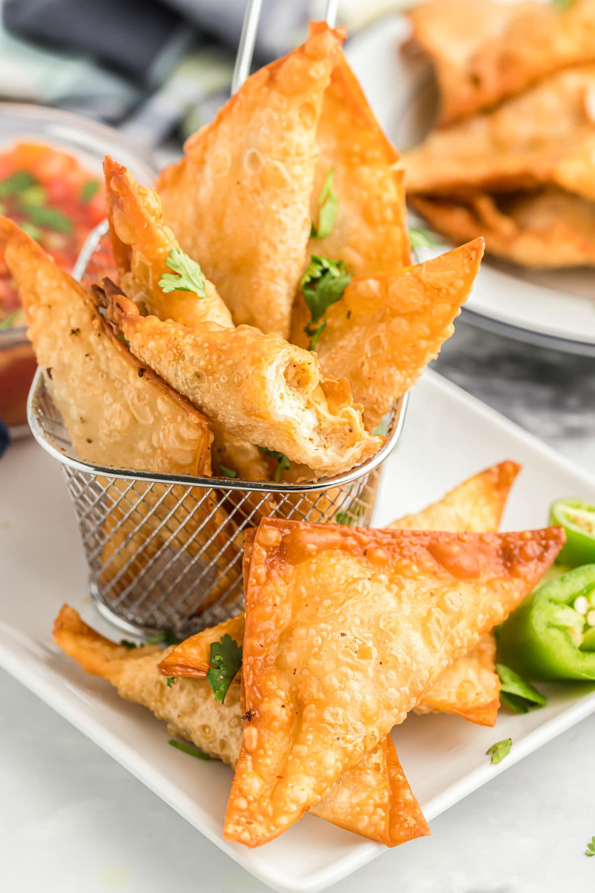 Fried mexican wontons in a basket served with salsa.