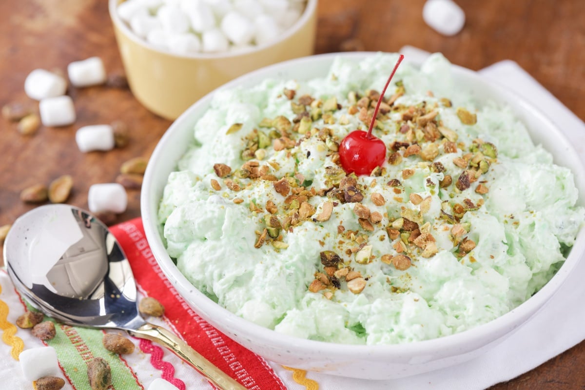 Bowl filled with pistachio salad topped with pistachio nuts.