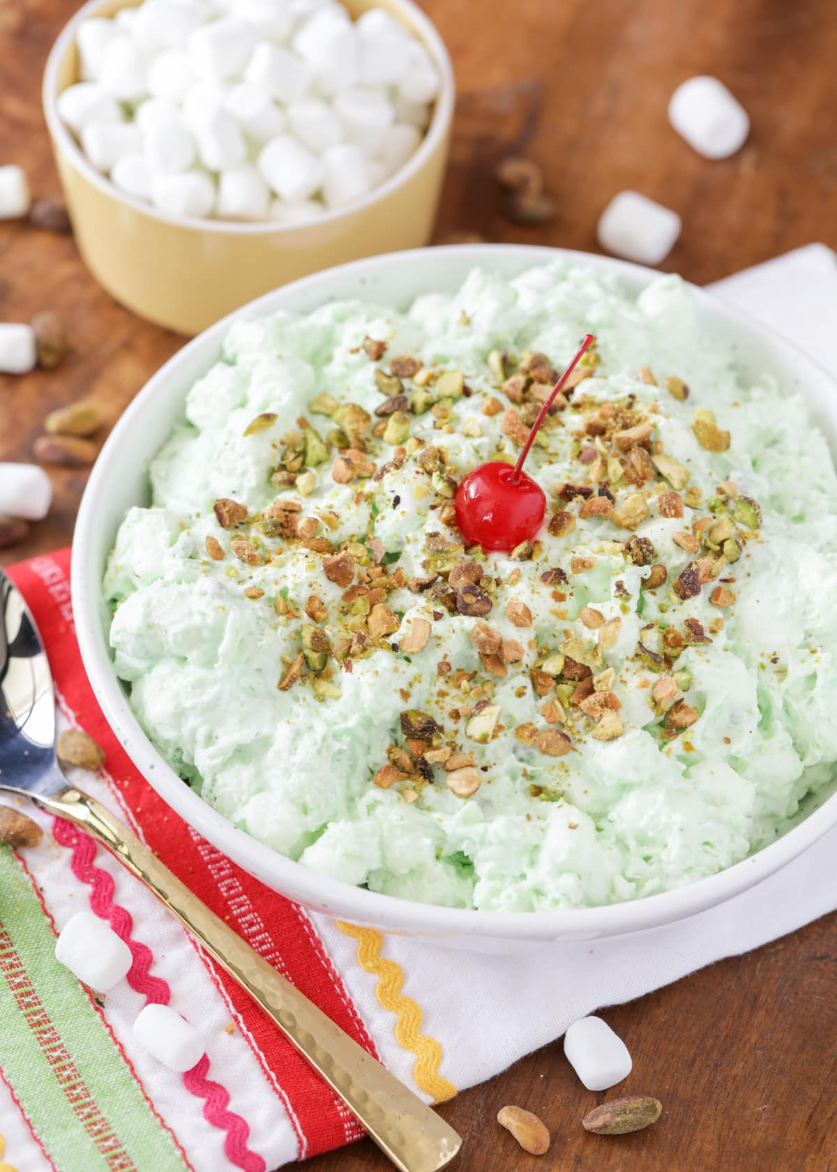 Pistachio pudding recipe in white bowl with chopped pistachios sprinkled on top.