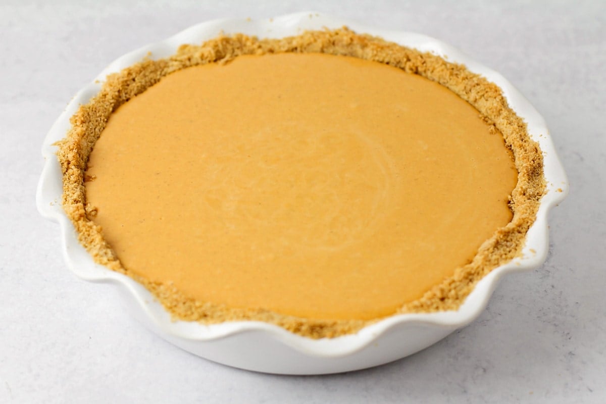 Pumpkin pie with graham cracker crust recipe ready to be baked.