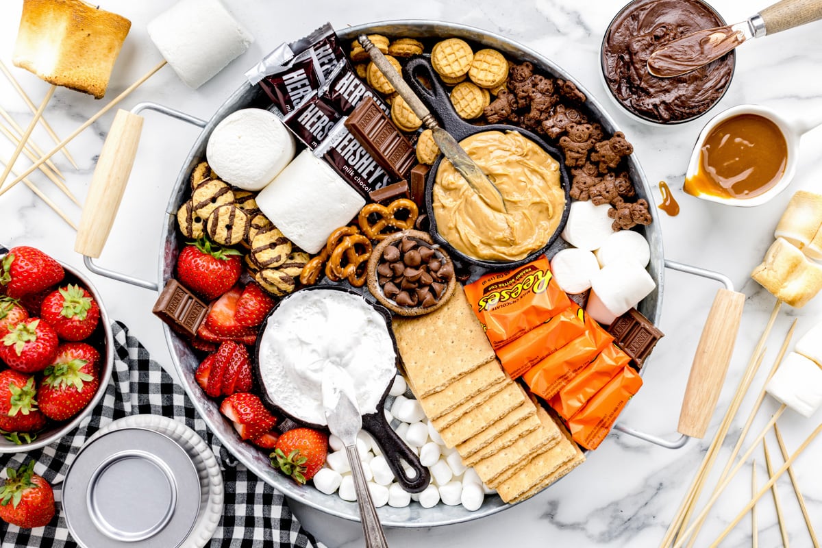 S'mores charcuterie board spread filled with marshmallows, chocolate and spreads.