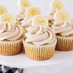 A platter of banana cupcakes topped with cinnamon cream cheese frosting.