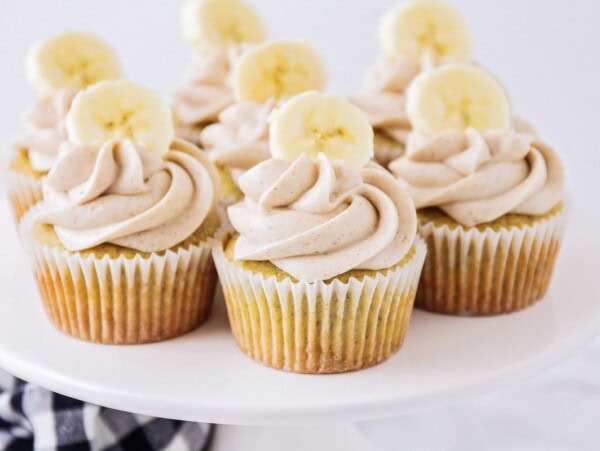 A platter of banana cupcakes topped with cinnamon cream cheese frosting.