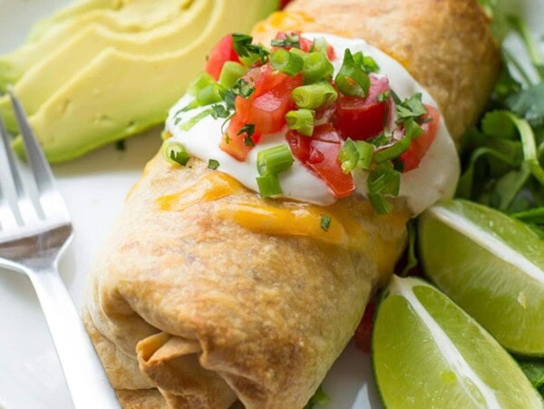 Baked chicken chimichanga topped with sour cream and pico.