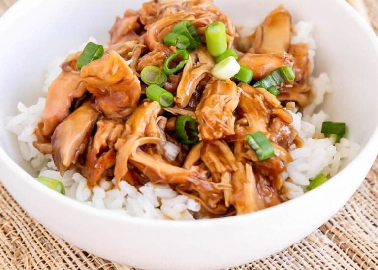 Crock pot teriyaki chicken served over white rice and topped with green onions.
