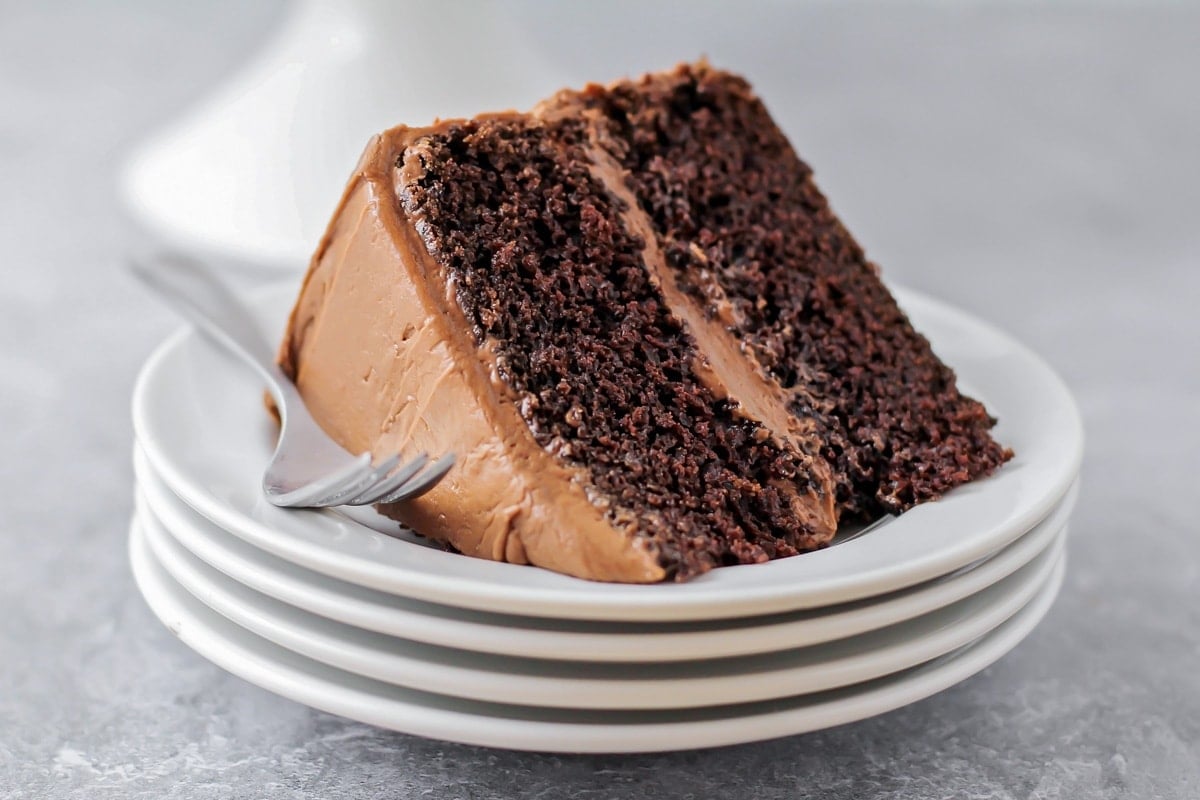 Slice of chocolate cake on a white plate.