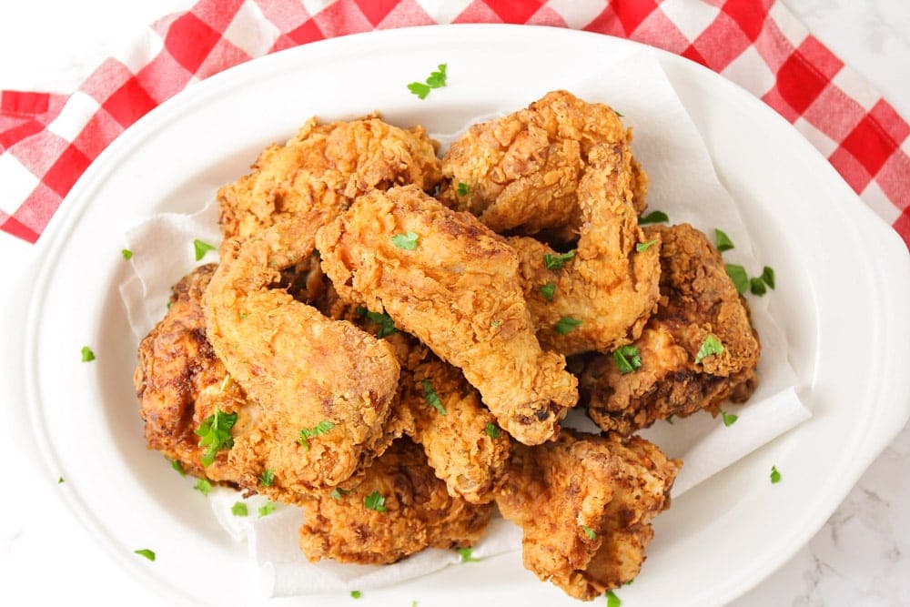 A white plate with fried chicken piled on top.