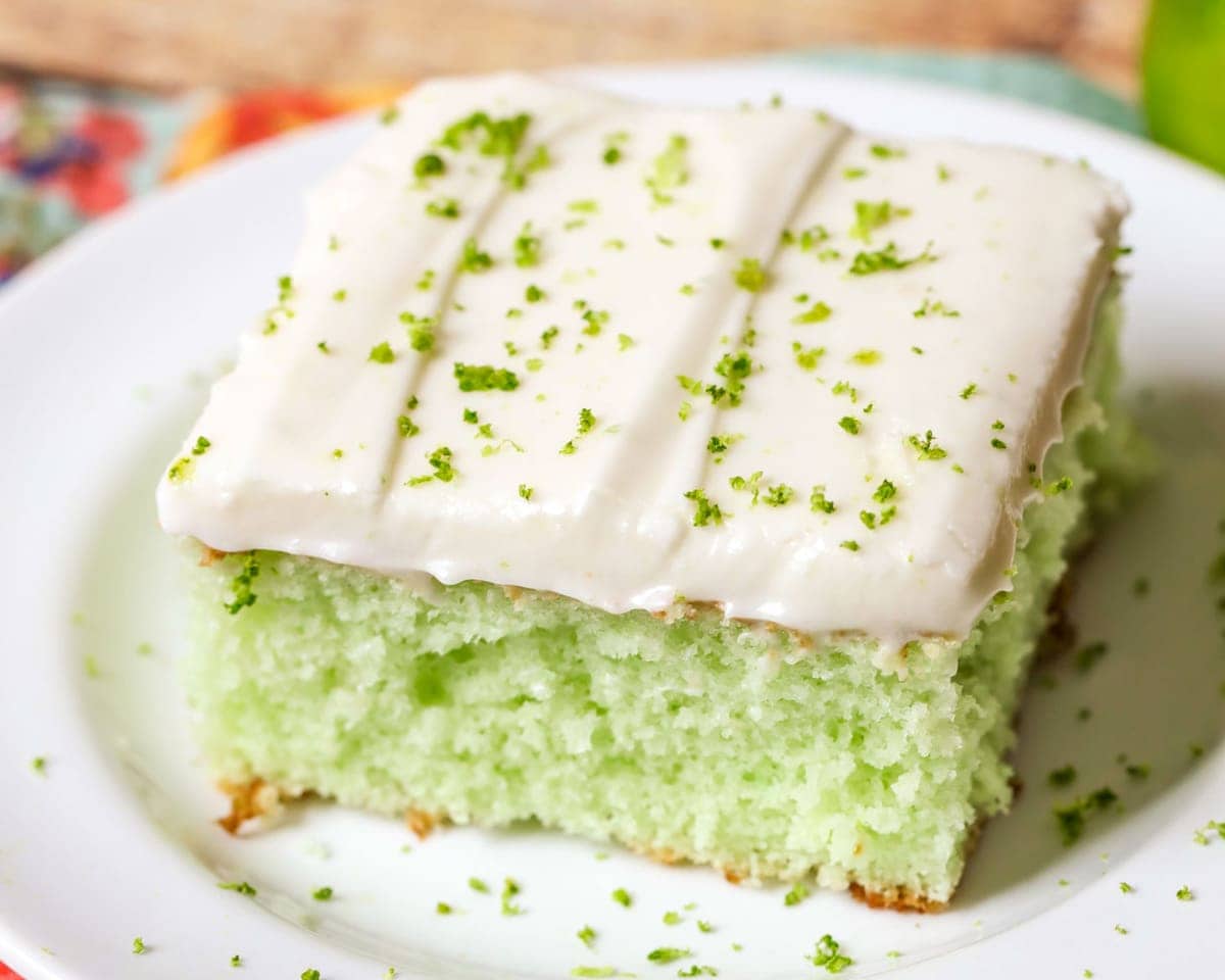 A slice of lime sheet cake on a white plate.
