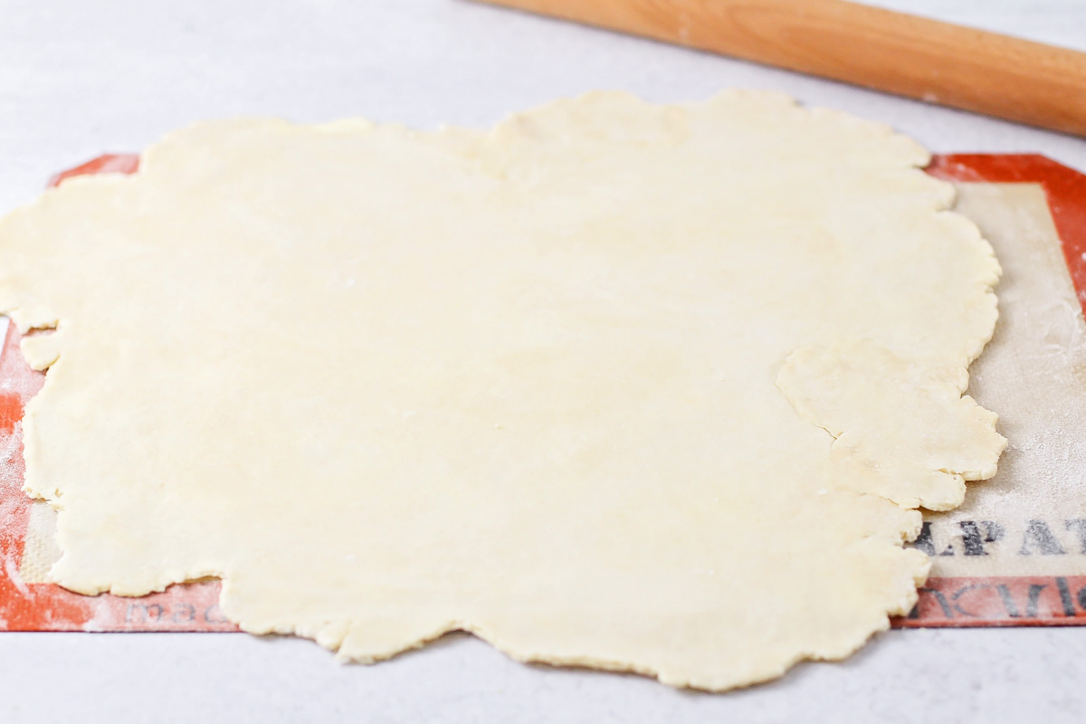 Rolling out homemade pie crust on a silpat mat.