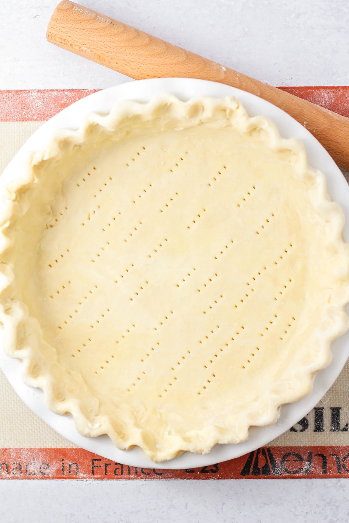 Prepared homemade pie crust in a baking dish ready for filling.
