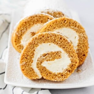 Homemade pumpkin roll sliced and served on a plate.