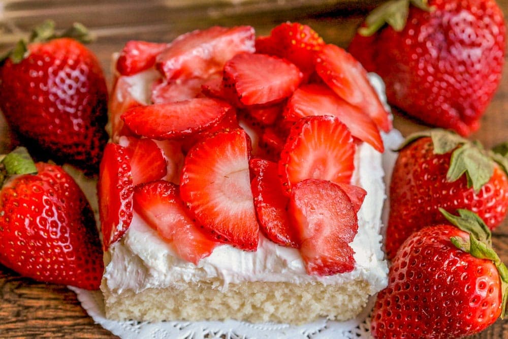 A square slice of strawberry shortcake bars on a doily.