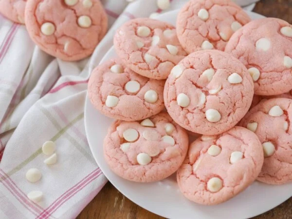 Strawberry cookies stacked on a white plate.