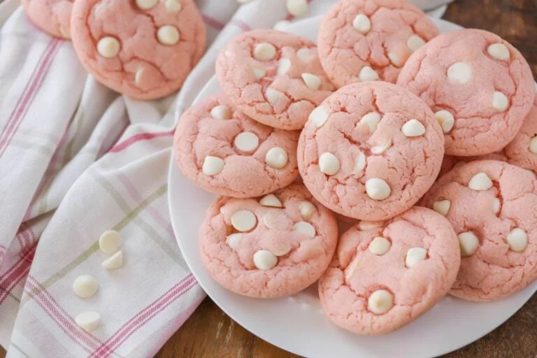 Strawberry cookies stacked on a white plate.