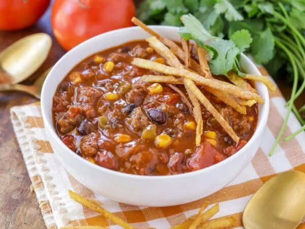 Taco soup served with fresh cilantro and tortilla strips.