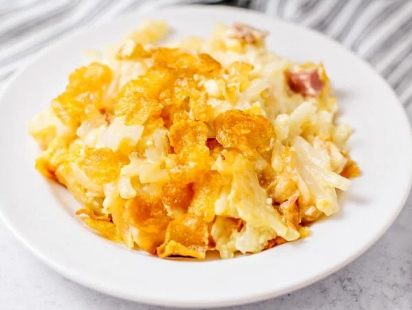 Crockpot Hashbrown Casserole recipe scooped out onto white plate.