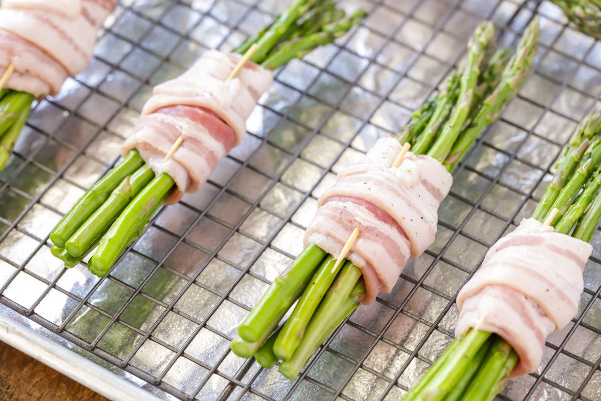 Bacon wrapped asparagus bundles on a ready for baking.