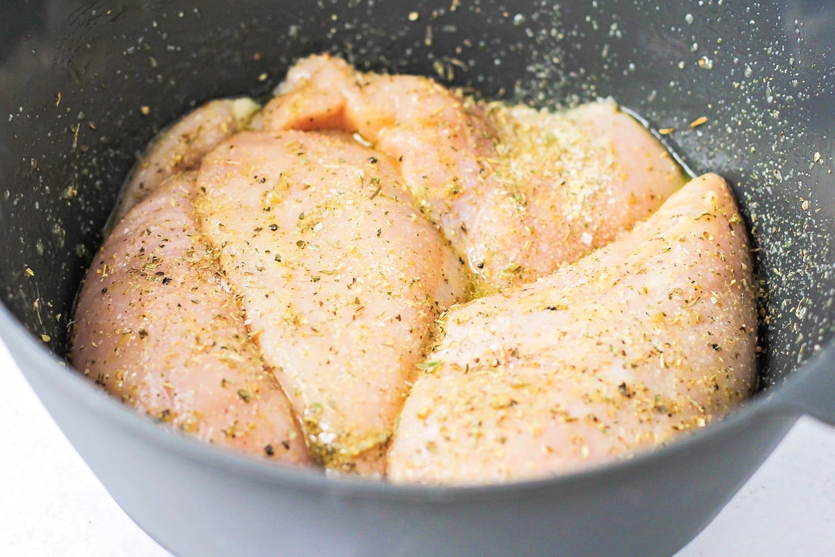 Seasoning the meat in preparation for baked chicken.