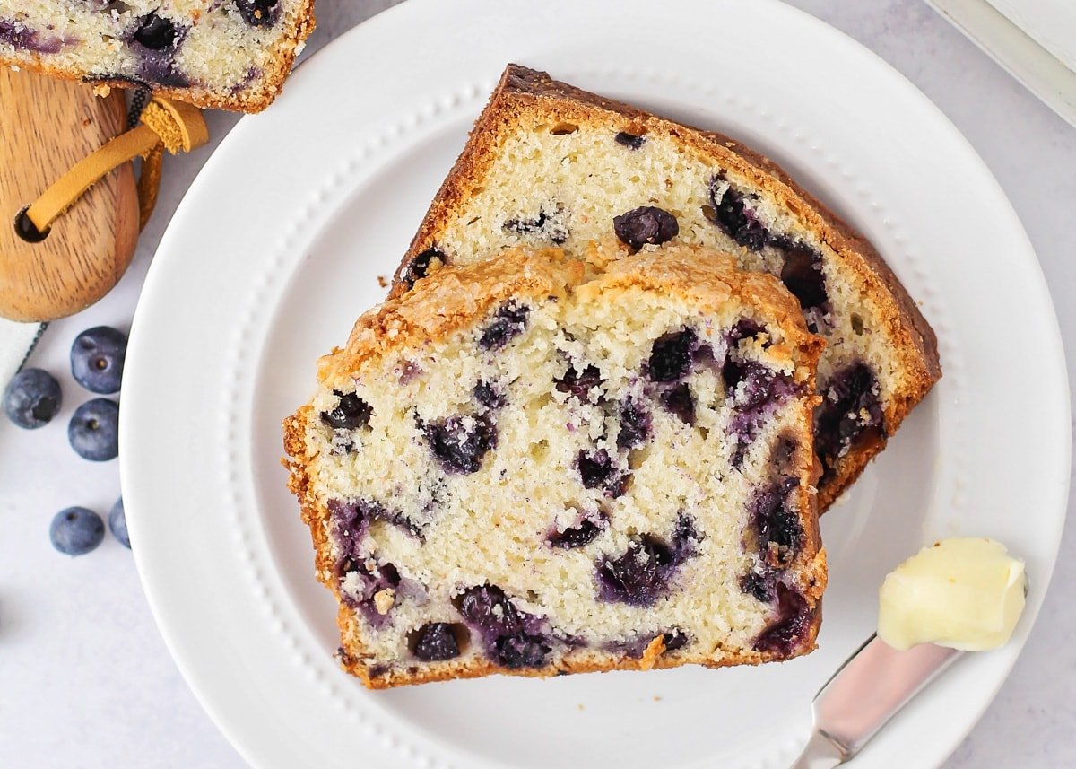 Two slices of blueberry bread on a white plate.
