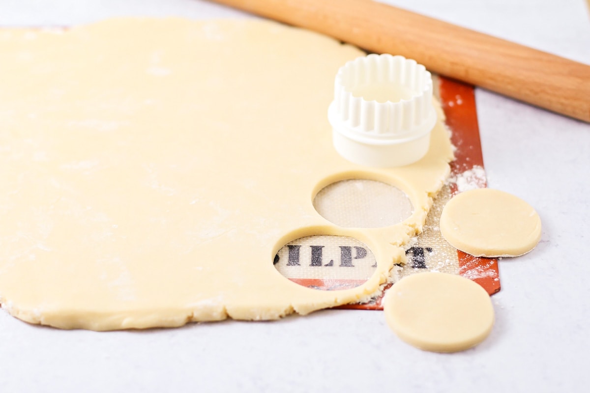 Cutting circles out of the rolled butter cookie dough.