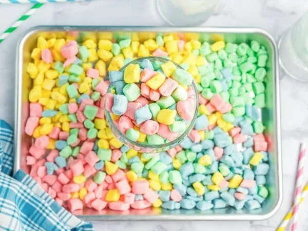 Butter mints recipe in bowl with a tray full of homemade butter mints.