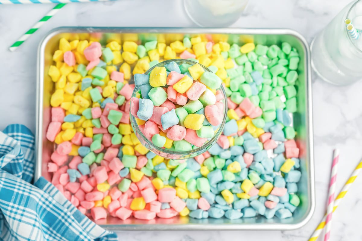 A cup and baking tray filled with colorful butter mints.