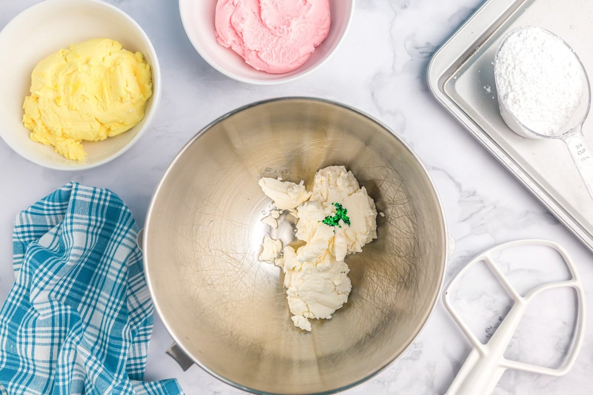 Adding color to butter mint batter in a bowl.