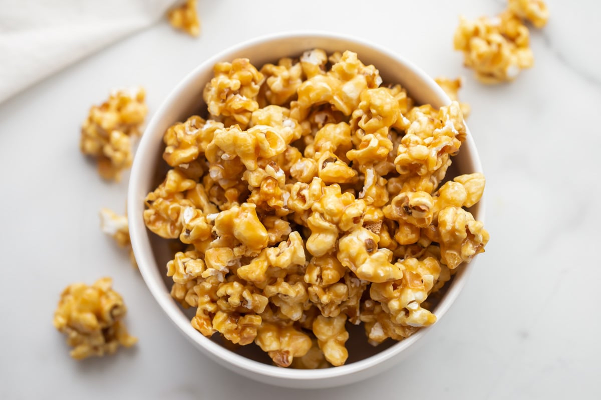 A white bowl filled with caramel popcorn.