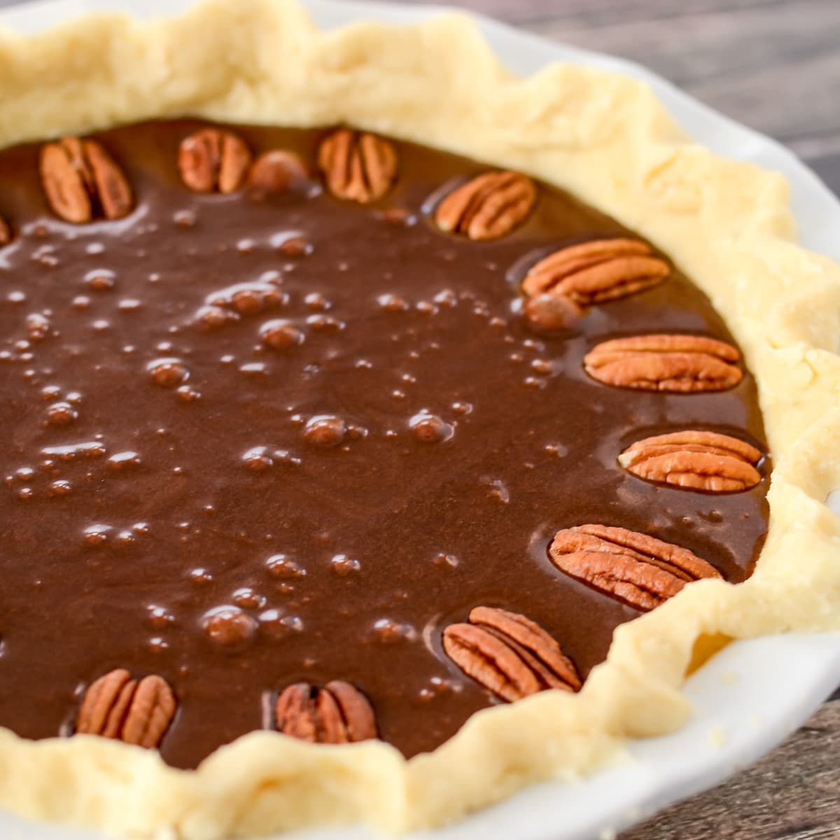 Chocolate and pecans in pie dish for Chocolate Pecan pie.
