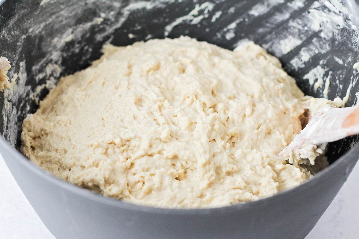 Bread dough rising in a grey bowl.