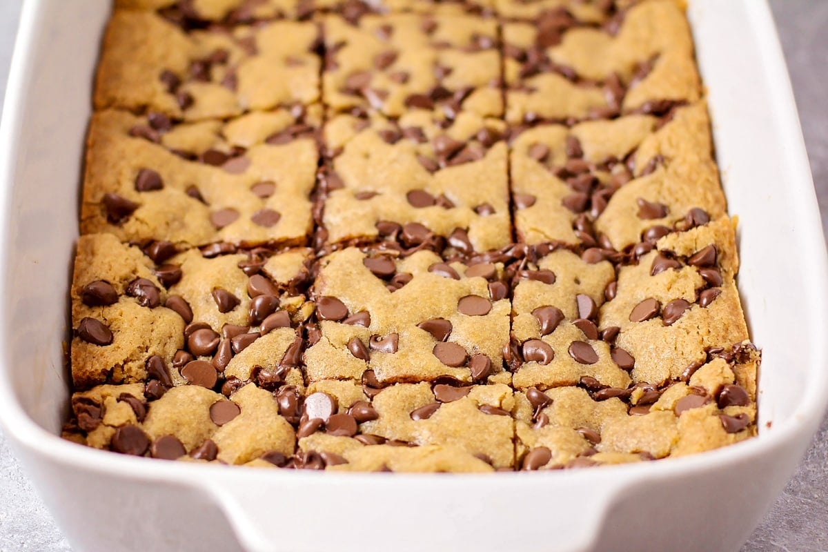 Cookie bar recipe cut up in a white baking dish.