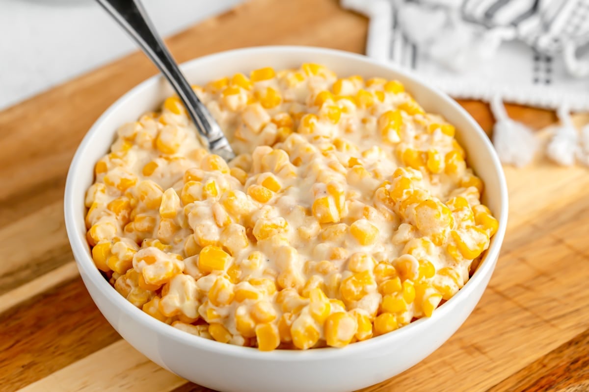 A white bowl filled with slow cooker creamed corn.