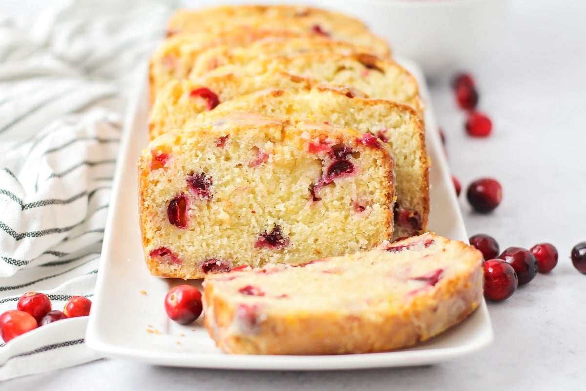 Orange Cranberry Bread sliced and served on a white plate.