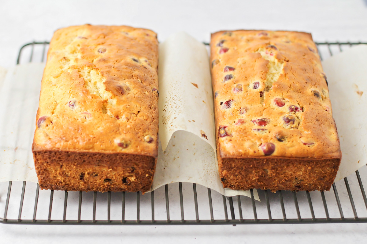 Fresh baked Cranberry Orange bread loaves cooling on a rack.