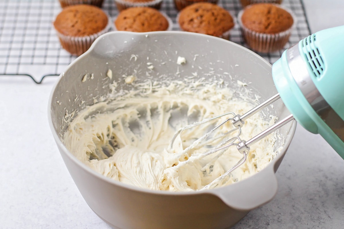 Whipping cinnamon cream cheese frosting for gingerbread cupcakes.