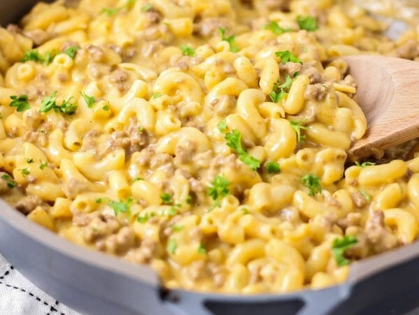 A pan of hamburger helper with a wooden spoon.