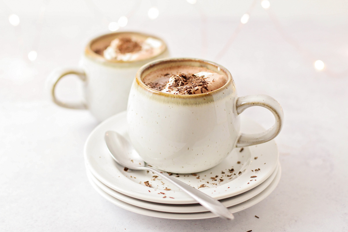 Hot chocolate topped with whipped cream and chocolate shavings.