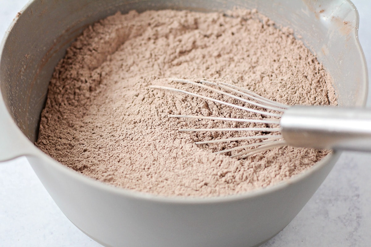 Whisking together ingredients for homemade hot chocolate recipe in a bowl.