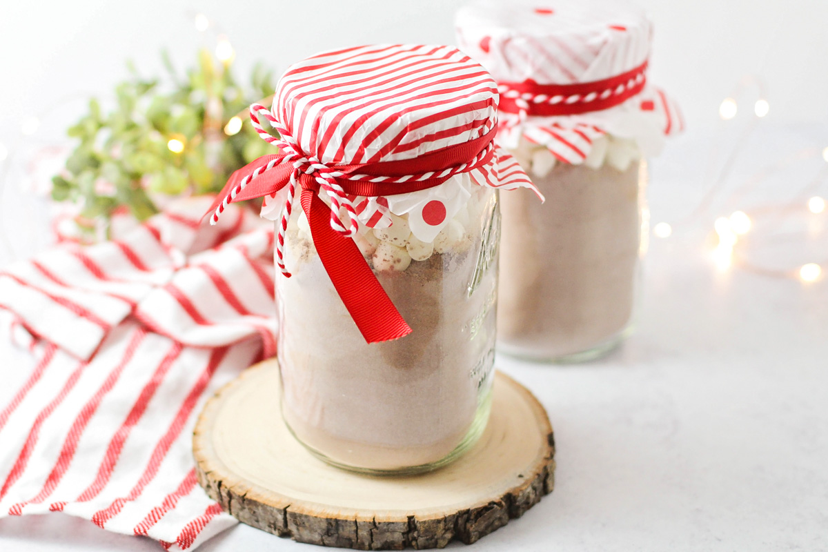 Two mason jar hot chocolate gift sets decorated for gifting.