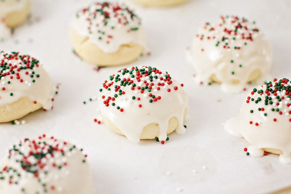 Italian Christmas cookies topped with glaze and festive sprinkles.
