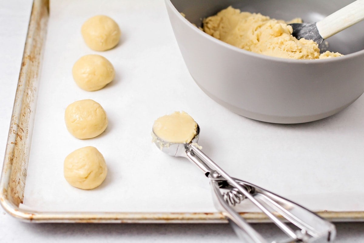 Dough balls scooped on a baking sheet for making Italian Christmas Cookies.